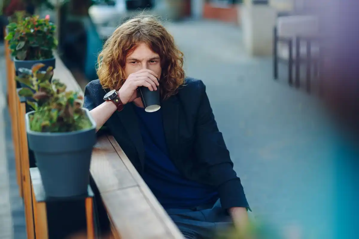 tired person coffee outdoors stretching Sweden
